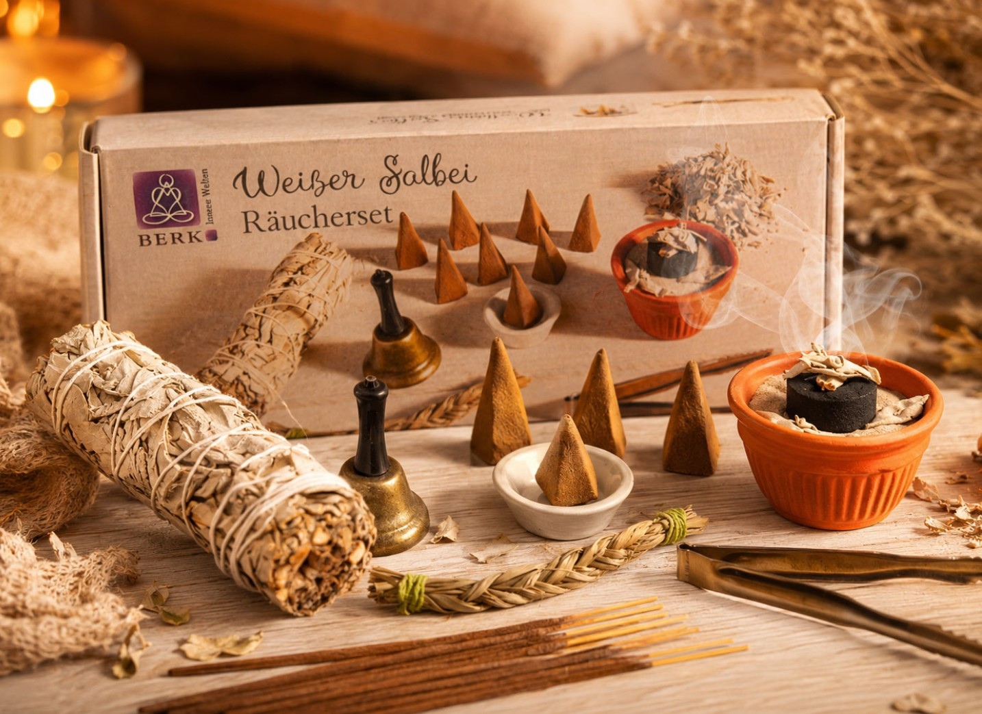Eine Packung „Weißer Salbei Räucherset“ mit Räucherkegeln, Gefäßen und einem gebündelten Salbeistab auf einem dekorierten Holztisch.