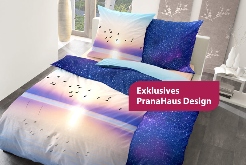 Wende-Bettwäsche, die auf einer Seite einen Sonnenuntergang am Meer und auf der anderen einen Nachthimmel zeigt. Davor steht auf einem roten Rechteck "Exklusives PranaHaus Design".