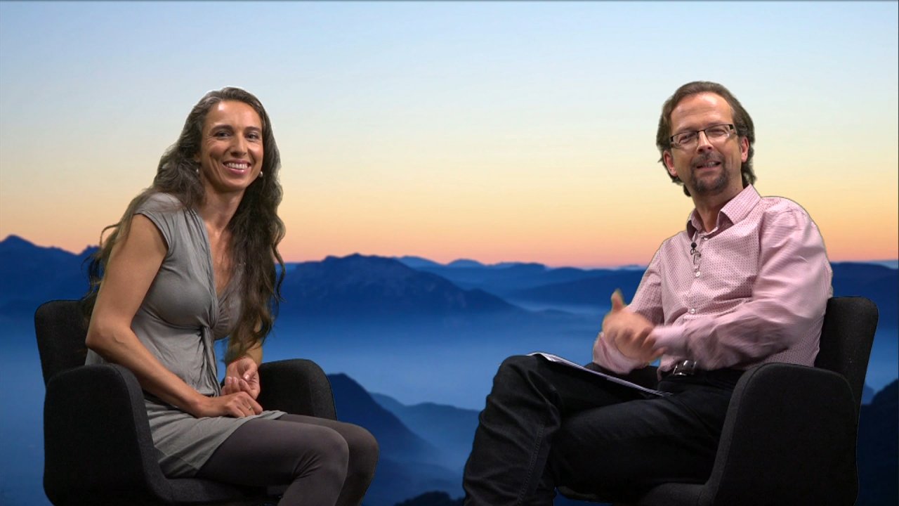 Vivian Dittmar und der Moderator Thomas sitzen in Sesseln, sie blicken zur Kamera. 